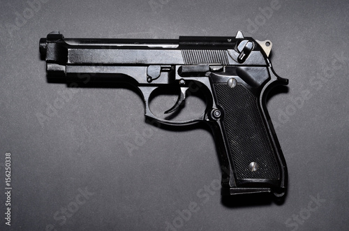 Used black metal 9mm pistol gun on black background photo