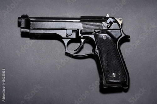 Used black metal 9mm pistol gun on black background