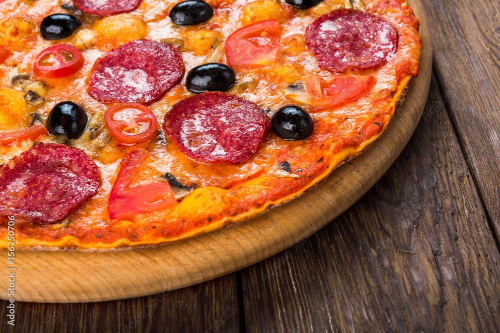 Delicious pizza with salami, mushrooms and olives Delicious pizza with salami, mushrooms and olives