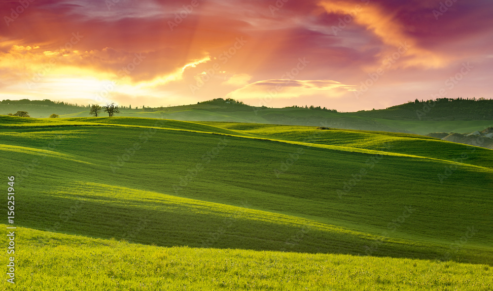 stunning sunset on green rolling hills in Tuscany