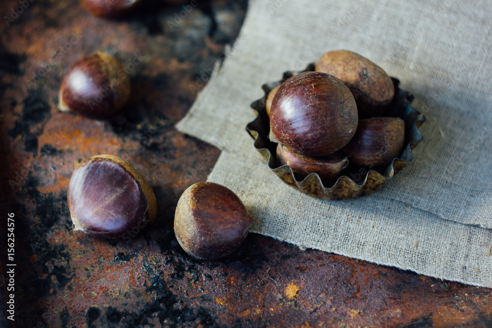 Obraz premium Chestnuts over rustic background