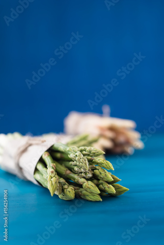 Bunch of fresh asparagus on blue wooden table