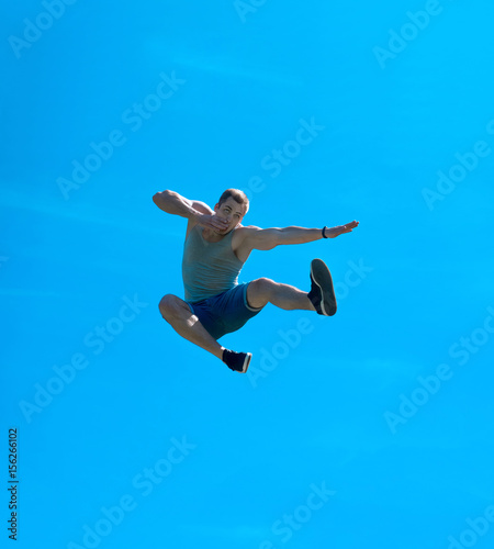 Jumping up guy. Background blue sky.