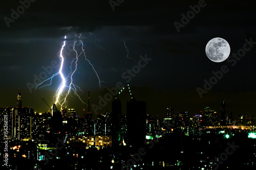 Dramatic thunder storm lightning bolt on the horizontal sky and city scape with super moon