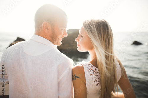 happy just married young wedding couple celebrating and have fun at beautiful beach sunset