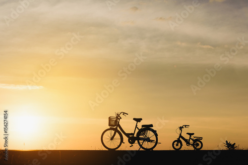 Silhouette of Two vintage bicycle on the road near the sea. Family travel and healthy lifestyle concept.