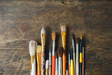 row of artist paintbrushes closeup on old wooden rustic table