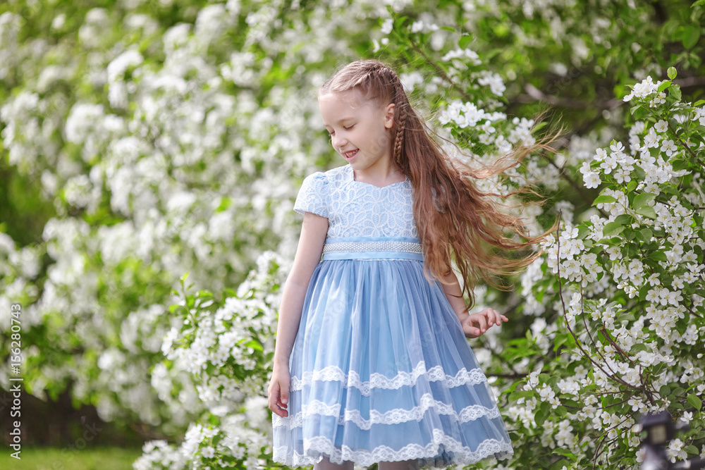 Cute little girl in blooming apple tree garden at spring Cute little girl in blooming apple tree garden at spring