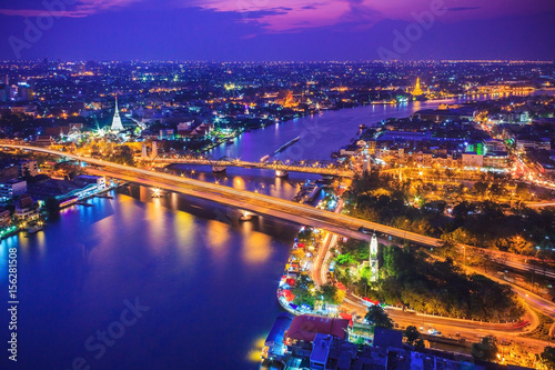Bangkok city skyline and Chao Phraya River under twilight evening sky.