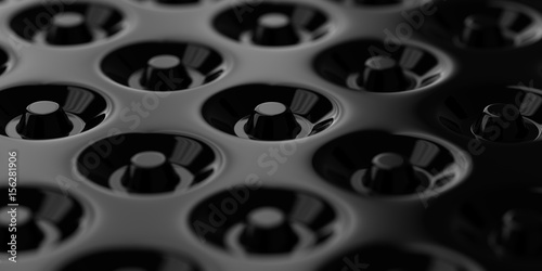 Repetitive donuts pattern being inset at the black smooth surface. 3D abstract illustration.