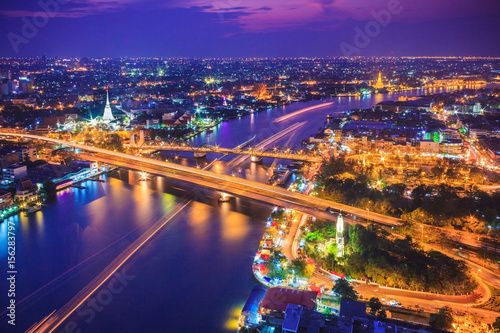 Bangkok city skyline and Chao Phraya River under twilight evening sky.