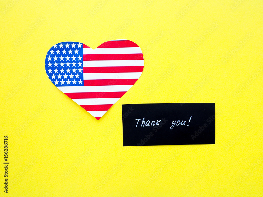 Obraz premium Thank you sign on a chalkboard with American flag on yellow background, USA
