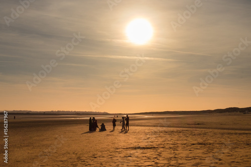 Silhouette of a family on Camber Sands beach at sunset in spring, East Sussex, England