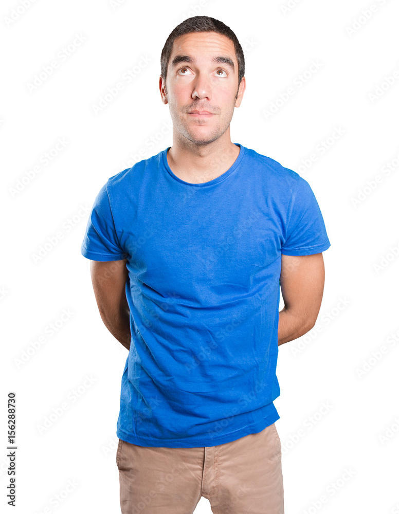Fototapeta premium Astonished young man looking up against white background