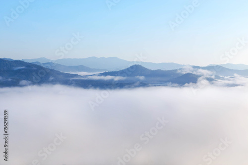  High angle view over tropical mountains with white fog in early morning in Thailand.