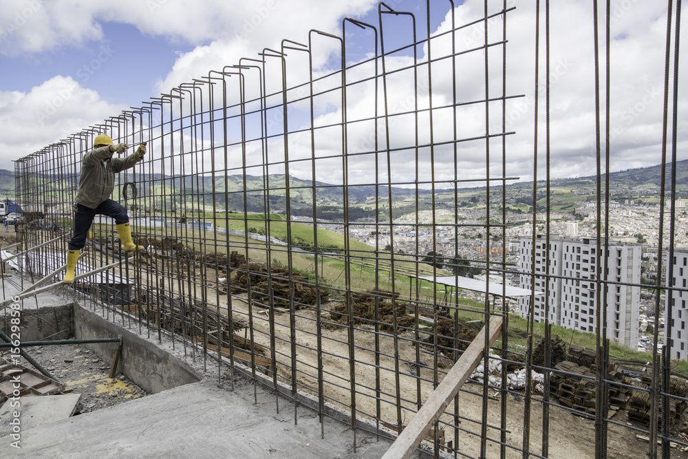 Fototapeta premium obrero trabaja en construcción en edificio de estructura en las alturas
