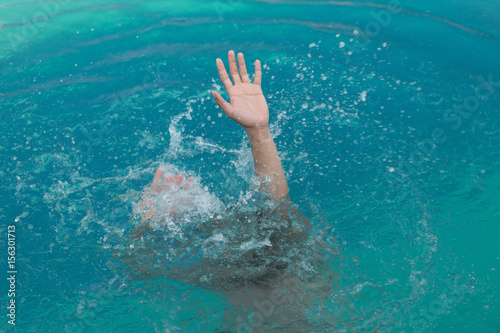 hand of drowning man in swimming pool asking for help