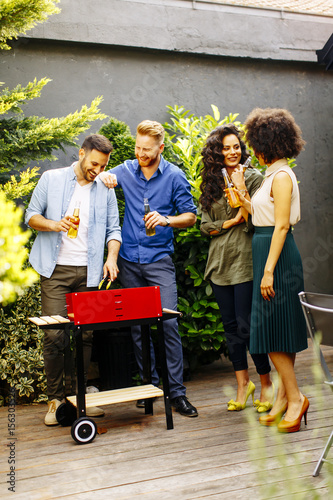 Happy friends grilling food...