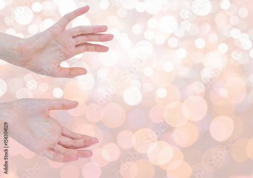 Hands open delicately with sparkling light bokeh background