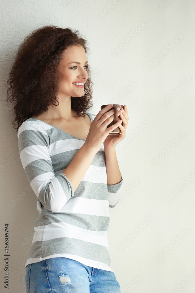 Young woman holding cup of coffee and looking at window Young woman holding cup of coffee and looking at window