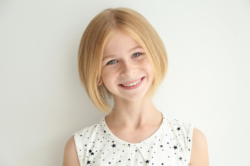 Portrait of cheerful teenager girl with freckles on white background