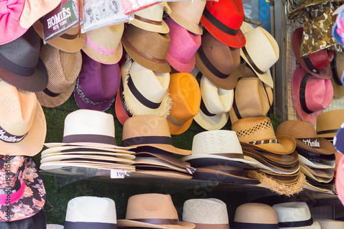 Market stall with craftsmanship hats in straw hats for sale.