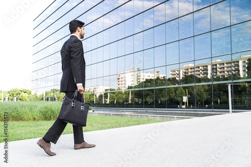Businessman or worker standing in suit near office building