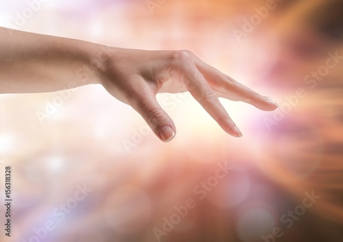 Hand stretched fingers with sparkling light bokeh background