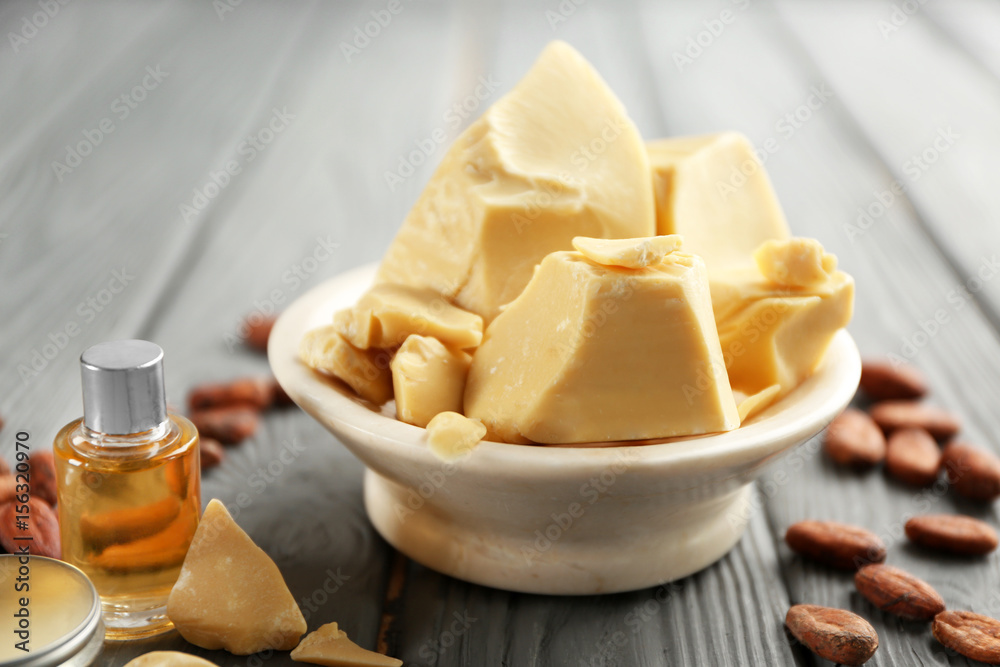 Composition with cocoa butter and cosmetics on wooden background Composition with cocoa butter and cosmetics on wooden background