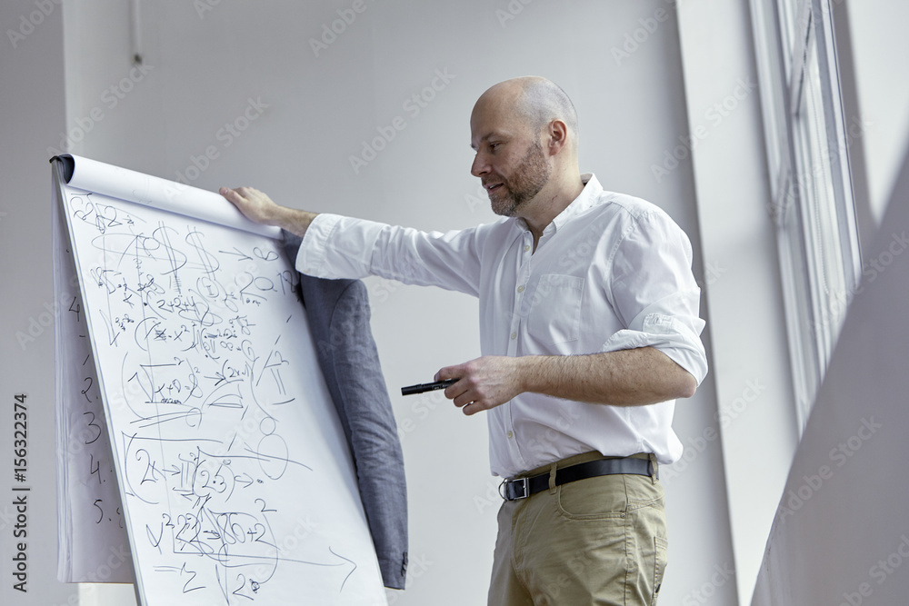 Bald Businessman Pointing at the Board with a Marker