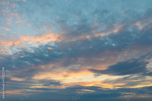 Clouds on a blue sky illuminated by the sun at sunset. © Moroshka