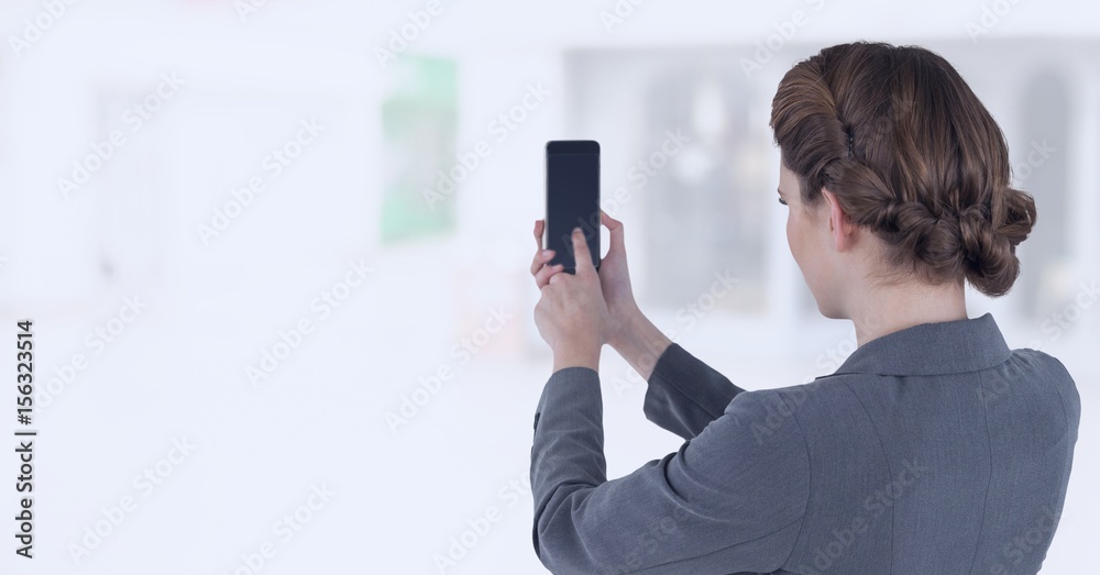 Businesswoman holding mobile phone in bright shopping mall Businesswoman holding mobile phone in bright shopping mall