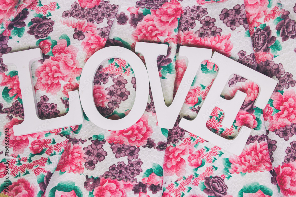 Fotografia do Stock: Palabra LOVE escrita con letras de madera blanca sobre  una tela de flores | Adobe Stock