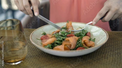 Woman eating salad sitting in cafe 
 photo