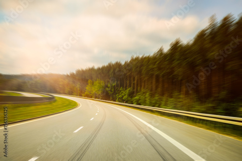 Turning Highway in the Beautiful Sunny Weather And Blue Cloudy Sky (Filtered image processed vintage effect and motion blur background). © Saulius