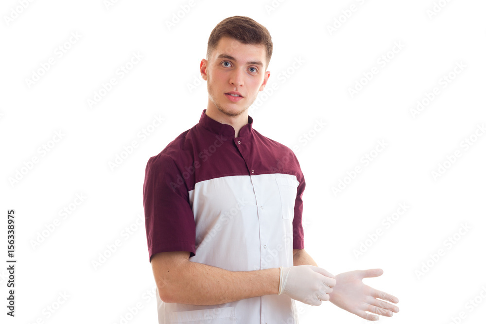 young man doctor in uniform and gloves looking at the camera young man doctor in uniform and gloves looking at the camera