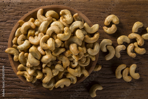 Cashew nuts in wood bowl on wood background