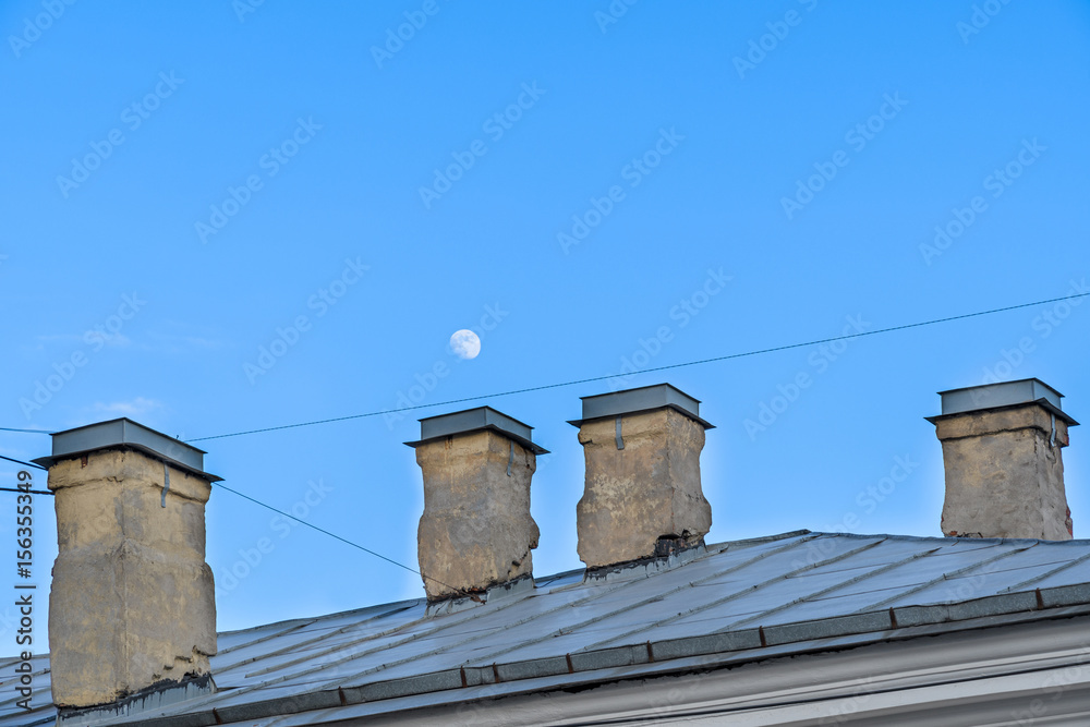 City views over the rooftops and the moon in the daylight City views over the rooftops and the moon in the daylight