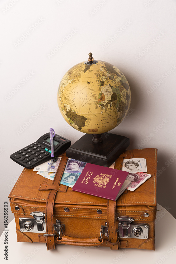 Libras esterlinas, pasaporte, maleta, mapa mundi y calculadora. Stock Photo  | Adobe Stock