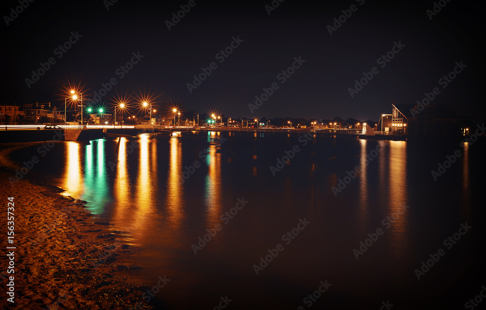 Night lights on the seashore. city skyline. big city lights at the beach. reflected in water