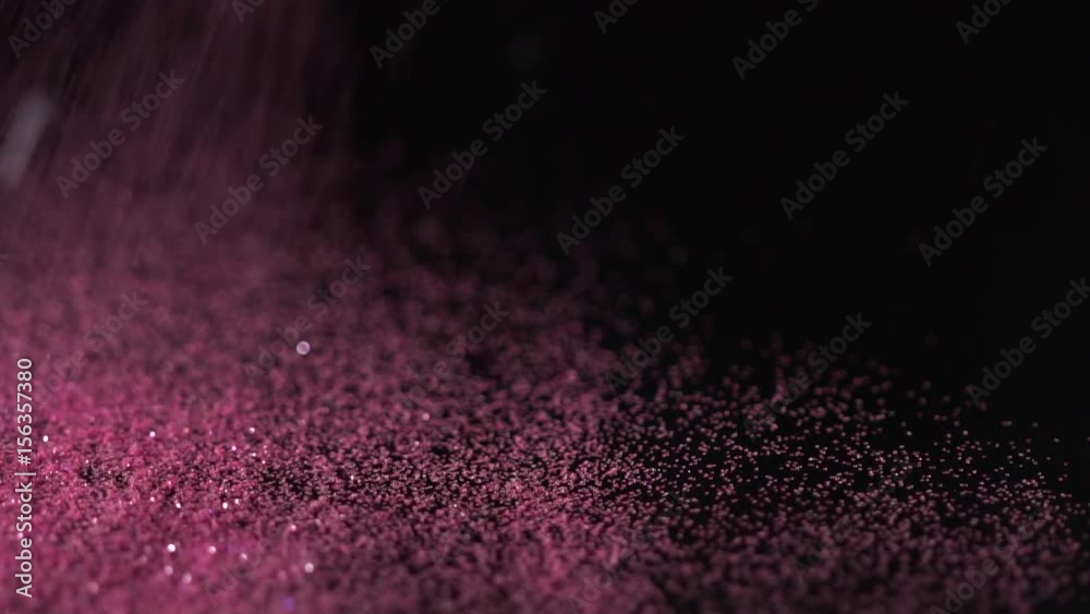 Pink glitter falling on the black background, abstract slow motion Pink glitter falling on the black background, abstract slow motion