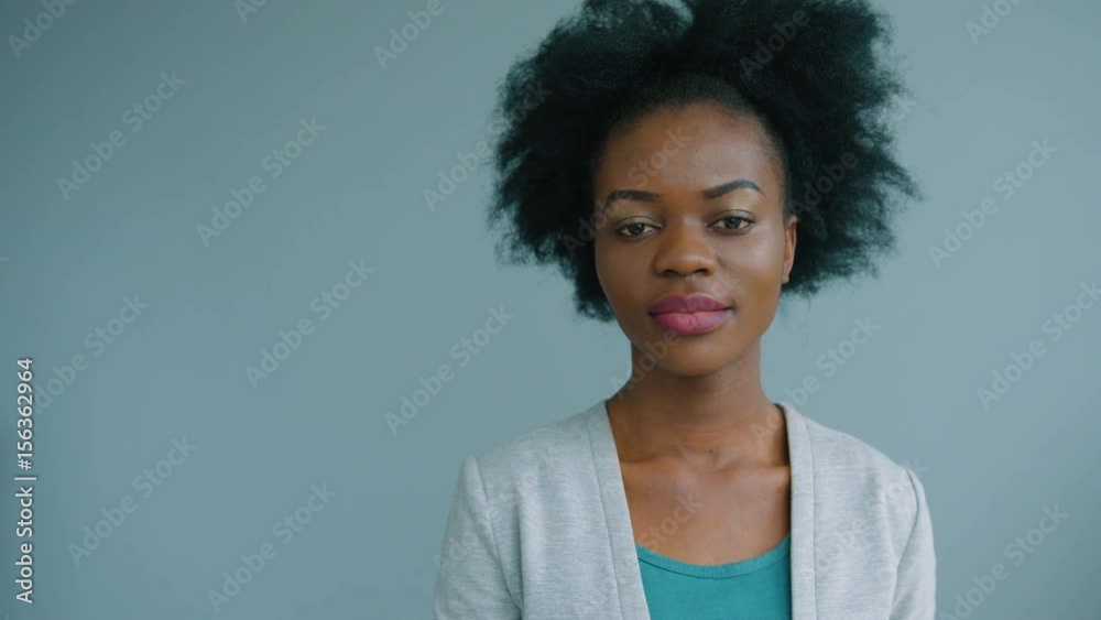 Close up portrait of beautiful african american woman turning head to camera and smiling. Close up portrait of beautiful african american woman turning head to camera and smiling.