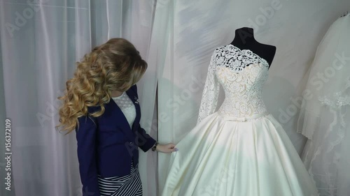 Woman choosing wedding dress in shop