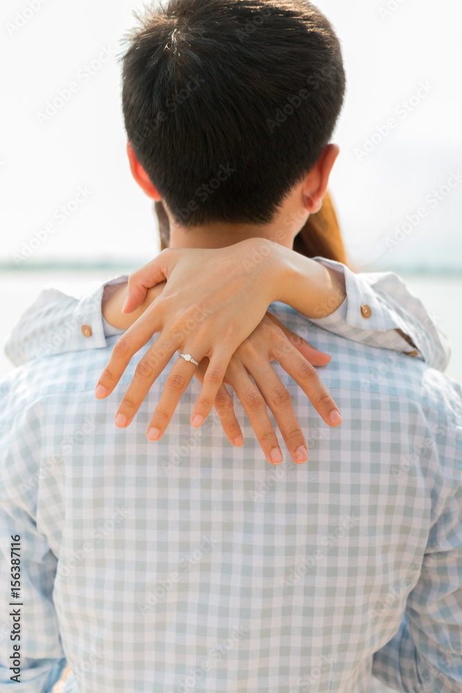 couple hug with selective focus on wedding ring