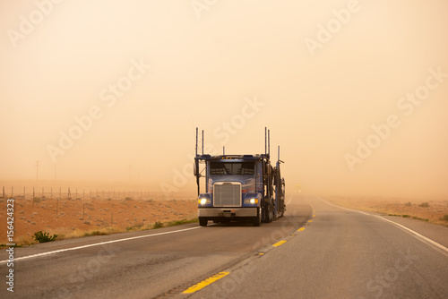 Car hauler semi truck in sand storm