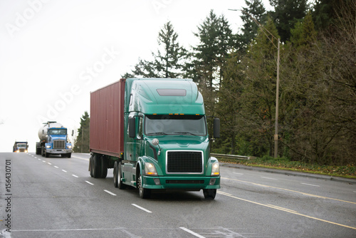 Bilde på lerret Different models of Semi trucks convoy on wide multiline road
