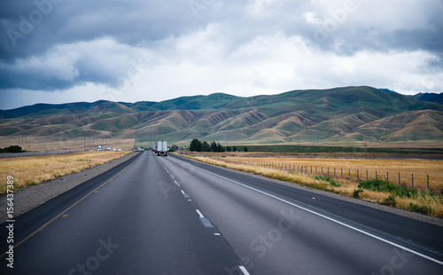 Scenic road with caravans semi trucks and undulating hills