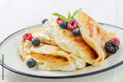 Tasty pancakes with cottage cheese and berries and powder sugar