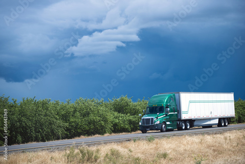 Wallpaper Mural Green semi truck on blue sky and orchard trees Torontodigital.ca