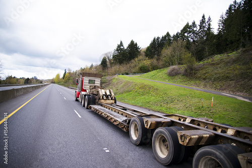 Long flat bed step down trailer on semi truck
